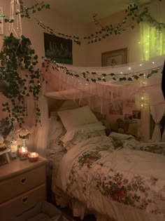 a bedroom with an unmade bed and lots of greenery hanging from the ceiling