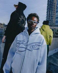 Three models pose wearing the signature logo zip hoodie in matcha, baby blue and black Streetwear Fashion Brand Logo, Campaign Shoot Fashion, Clothing Brand Photography Inspiration, Clothing Brand Campaign, Photoshoot Clothes Ideas, Hoodie Campaign, Photoshoot Clothing Ideas, Hoodies Photoshoot