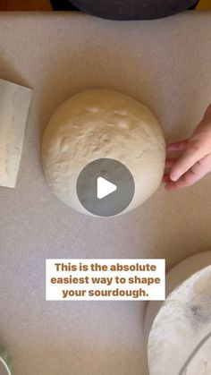 a person holding a piece of bread on top of a counter