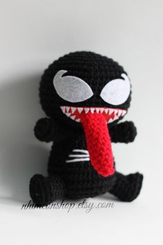 a crocheted stuffed animal with its tongue out and teeth on it's face