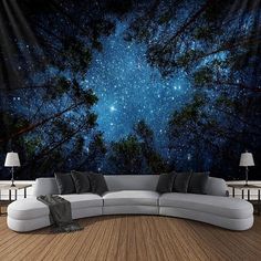 a couch sitting on top of a wooden floor under a sky filled with stars