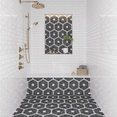 a bathroom with black and white tiles on the floor, shower head, and mirror