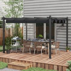 an outdoor dining area with wooden decking and pergolated patio furniture on it