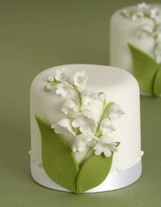 two cakes decorated with white flowers and green leaves