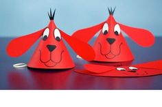 two red paper hats shaped like dogs on a table