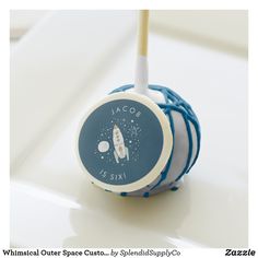 a blue and white lollipop with a rocket ship on it's side