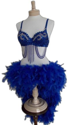 a mannequin with blue feathers and beads on it's chest, next to a dress form