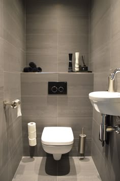 a white toilet sitting in a bathroom next to a wall mounted faucet and sink