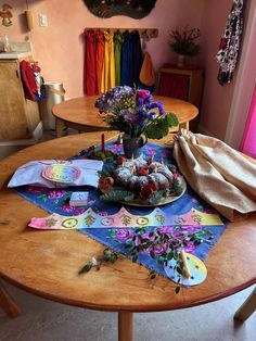 a wooden table topped with cake and flowers on top of it next to a window