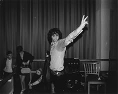 black and white photograph of young man with arms in the air while other people look on