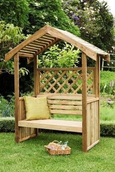 a wooden bench sitting on top of a lush green field next to a garden area