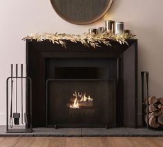 a fire place with logs and candles next to it