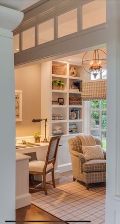 a living room filled with furniture next to a window covered in blinds and bookshelves