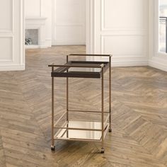 an empty room with wood flooring and a metal cart in the middle of it