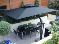 an outdoor dining area with table, chairs and umbrella