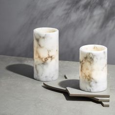 two marble candles sitting on top of a table