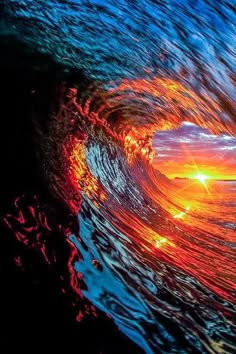 an ocean wave is shown with the sun setting in the distance and it's colors changing