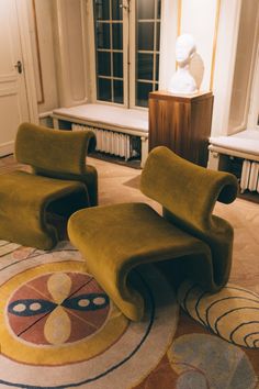 two green chairs sitting on top of a rug