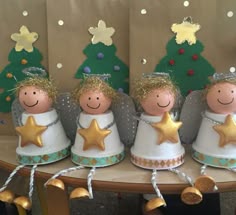 five little angel figurines with gold stars on their heads, and one is holding a star