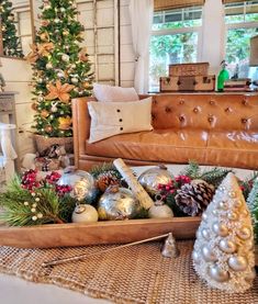 a living room decorated for christmas with ornaments and decorations on the table, including a couch