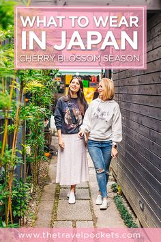 two women walking down a path with the text what to wear in japan cherry blossom season