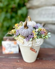 small crocheted pumpkins are sitting in a flower pot