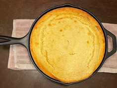 a cast iron skillet sitting on top of a table next to a napkin and fork