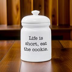 a white cookie jar with the words life is short, eat the cookie on it