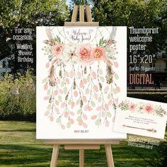 an easel with flowers and leaves on it next to a wedding card in the grass