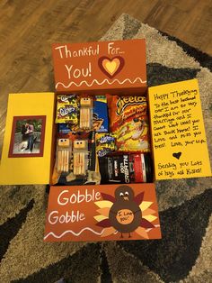 an open thanksgiving card box with candy, candies and other items in it on the floor