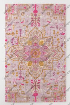 a pink and gold rug with an ornate design