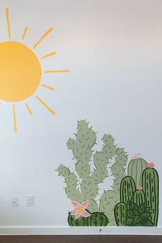 a wall painted with cactus and sun on it