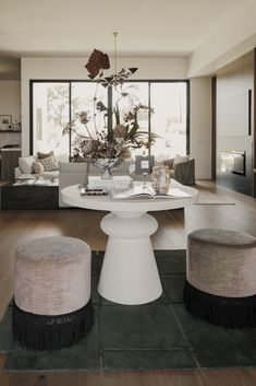 a living room filled with furniture and a large window covered in lots of natural light