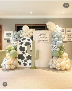 a room decorated with balloons and a cow theme