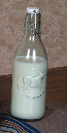 a glass bottle filled with milk sitting on top of a table