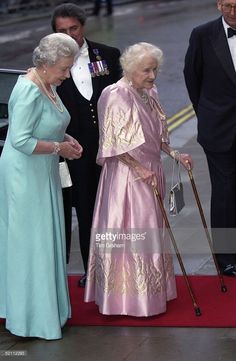 the queen and prince are walking down the red carpet with their canes in hand