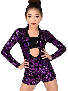 a woman in a purple and black leotard with her hands on her hips