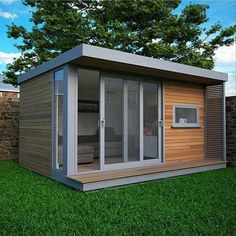 a small wooden shed sitting on top of a lush green field