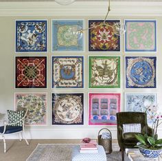 a living room filled with lots of colorful art on the wall above a green chair