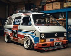 an old van is parked in a garage next to some boxes and other items on the shelves