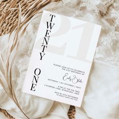 a white wedding card with the number twenty one printed on it next to some wicker baskets