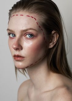 a woman with red stitches on her face