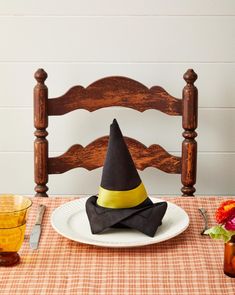 a table topped with a white plate covered in a witches hat