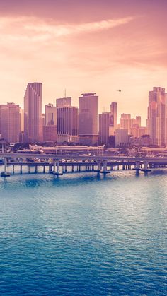 an image of a city skyline taken from the water's edge at sunset or sunrise