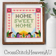 the cross stitch pattern is displayed next to a vase with flowers and a white vase