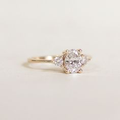 a three stone diamond ring on a white surface