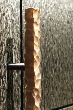 a tall vase sitting next to a metal door