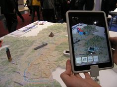 a person is looking at a map on a tablet screen while others stand in the background