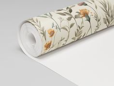 a roll of white paper with flowers and leaves printed on the side, sitting on top of a gray surface