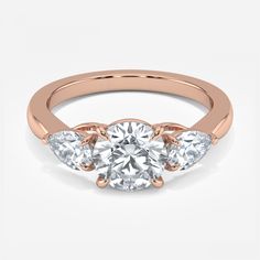 three stone engagement ring in rose gold with diamonds on the sides and an accent band